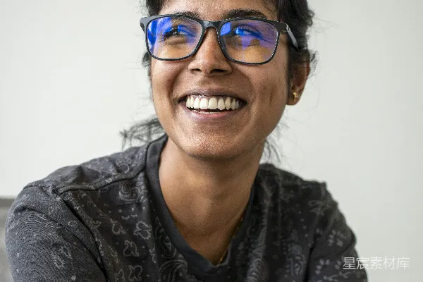 高清摄影 戴眼镜的女人微笑着，抬头向上看。