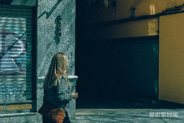高清摄影 一个女人在走过一座建筑物的街道上行走。
