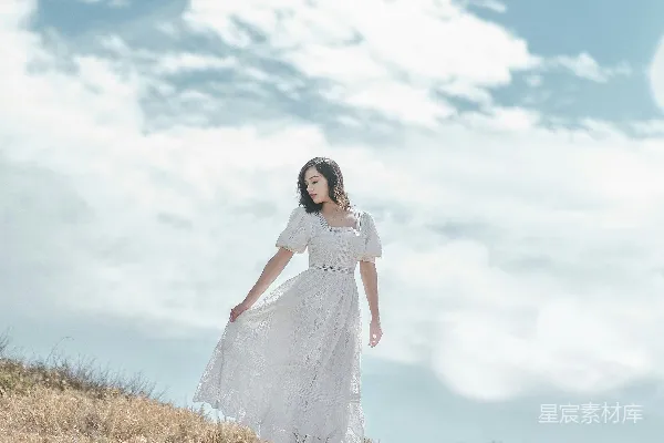 高清摄影 一个穿着白色连衣裙的女人站在田野里