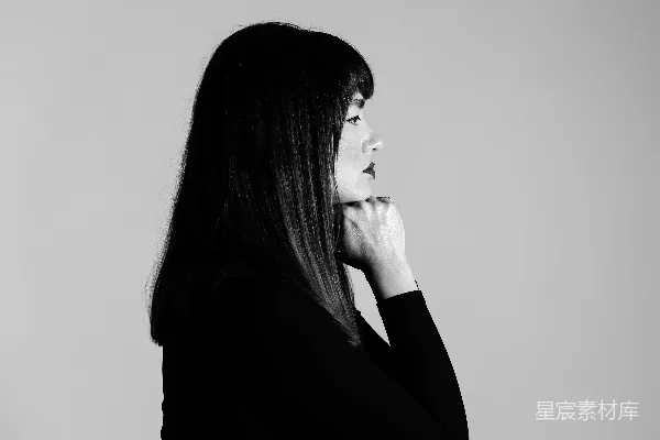 高清摄影 一位女士站在镜子前，手托着下巴。