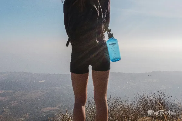 高清摄影 穿黑色夹克和蓝色牛仔短裤的女人站在白天的棕色草地上。