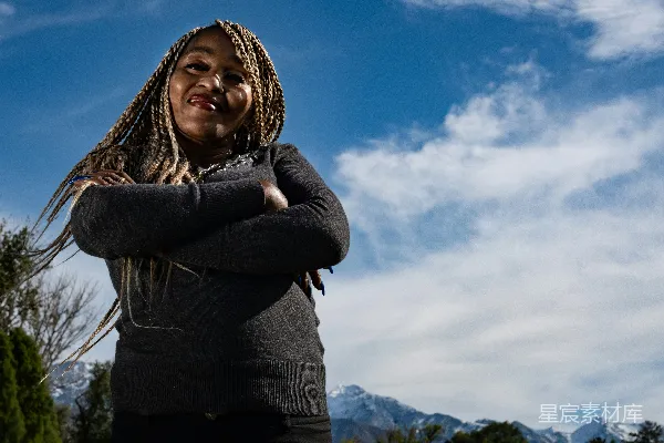 高清摄影 一个留着麻花辫的女人交叉双臂站着。
