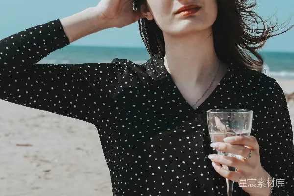 高清摄影 穿黑色V领长袖衬衫的女人拿着一个透明的酒杯