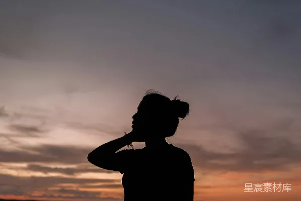 高清摄影 一个女人站在海滩上，靠近海洋。