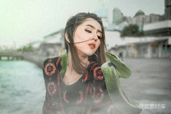 高清摄影 穿着黑色和粉色花卉长袖衬衫的女人手里拿着绿色的香蕉