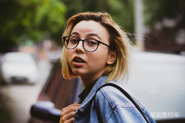 高清摄影 穿着蓝色牛仔夹克，戴着黑色框架眼镜的女人