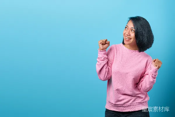高清摄影 一个穿着粉红色毛衣的女人正在摆姿势拍照。