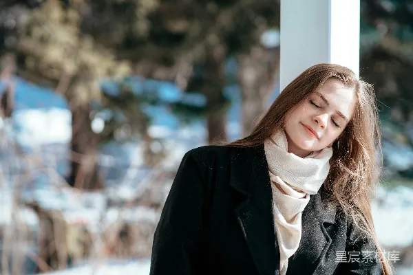 高清摄影 一个穿着黑色外套的女人靠在一个柱子上。
