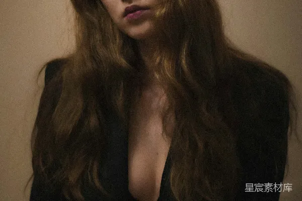 高清摄影 一个留着棕色长发的女子穿着黑色西装。