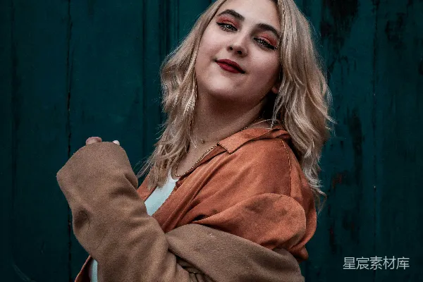 高清摄影 一个女人站在一扇绿色门前。