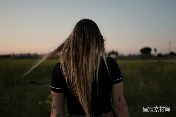 高清摄影 穿着黑色T恤的女子站在白天的绿草地上