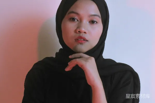 高清摄影 一位戴着黑色头巾的女性摆姿势拍照。