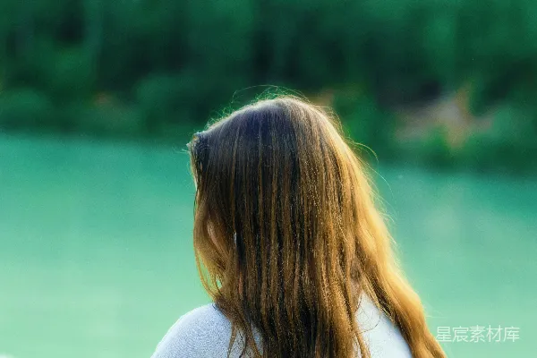 高清摄影 一个女人坐在湖边。