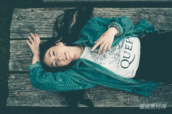 高清摄影 穿着蓝色牛仔夹克的女人躺在木制地板上。