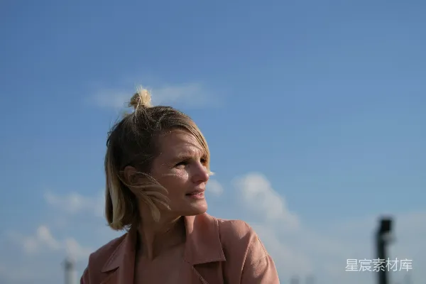 高清摄影 一个穿着粉色夹克的女人坐在长椅上。