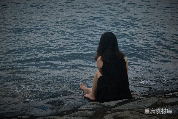 高清摄影 一位女士坐在水边的边缘。
