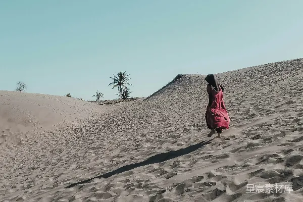 高清摄影 穿着红色连衣裙的女人在白天的沙滩上行走。