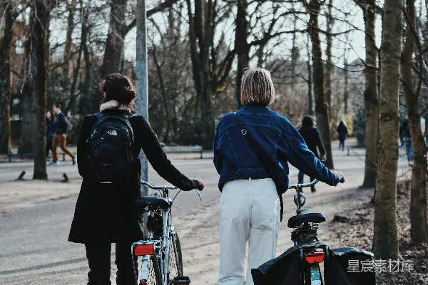 高清摄影 一个男人和一个女人在白天骑着一辆红色的自行车。