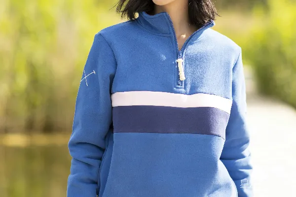 高清摄影 一个穿着蓝色毛衣的女人站在码头上。