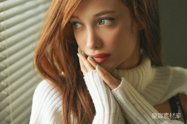 高清摄影 一个红发女子穿着白色毛衣。