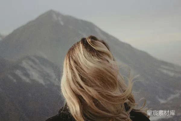 高清摄影 一个金发女人正看着一座山。