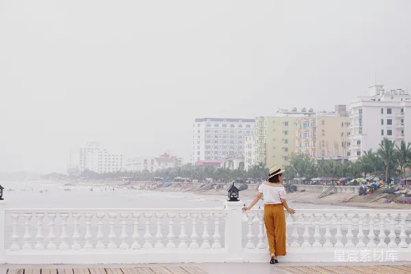 高清摄影 一个女人站在混凝土围栏旁边。