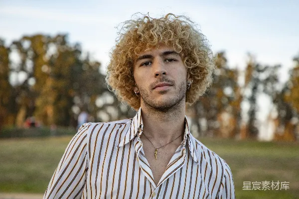 高清摄影 一个留着卷发的男人穿着条纹衬衫。