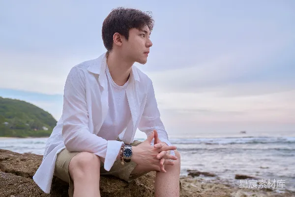 高清摄影 一个男人坐在海边的岩石上。