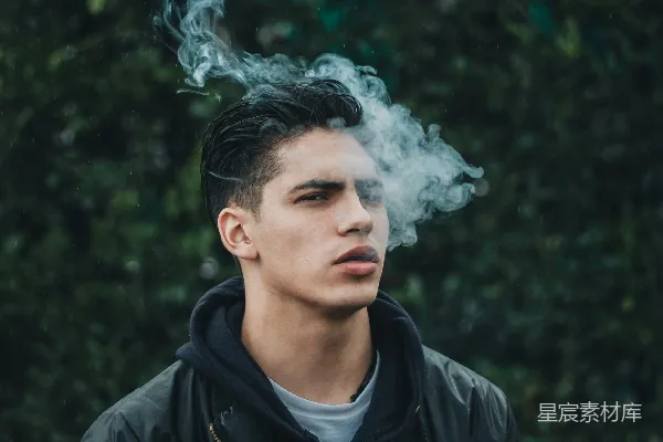 高清摄影 男人在绿叶树旁吸烟