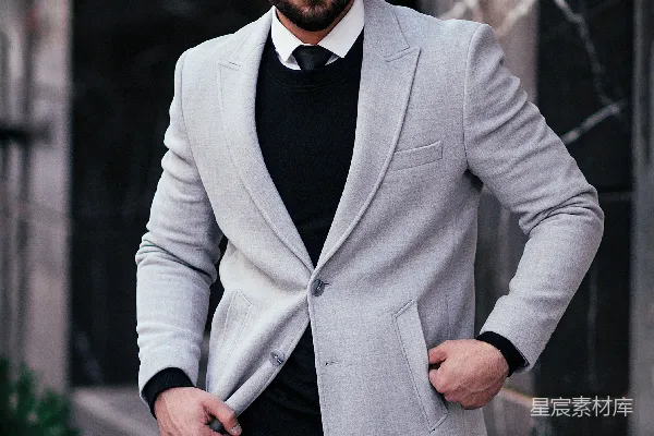 高清摄影 一个穿着西装并戴着墨镜的男人站在人行道上。