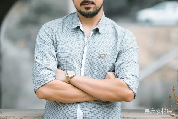 高清摄影 一个穿着蓝色长袖衬衫和黑色牛仔裤的男人站在白天的棕色岩石附近。