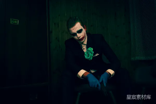 高清摄影 一个装扮成小丑的男人坐在椅子上。