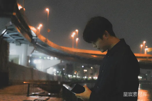 高清摄影 一个男人在晚上看着手机。