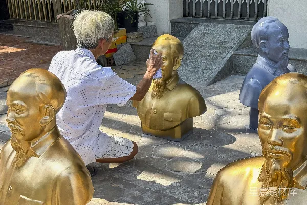 高清摄影 一个男人跪在一群金色雕像旁边。