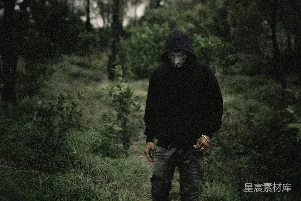 高清摄影 穿黑色连帽衫的男人站在白天的绿色草地上。