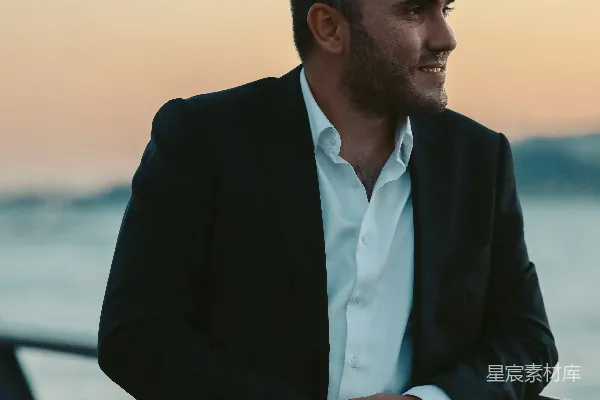 高清摄影 一个穿着西装的男人站在海边。