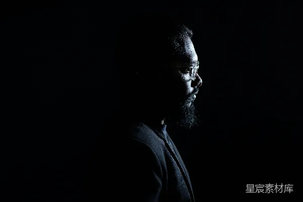 高清摄影 一个留着胡子的男人站在黑暗中。