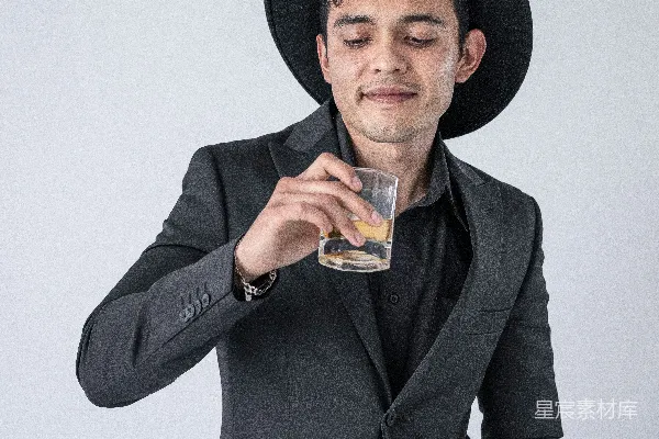高清摄影 戴黑帽子的男人拿着透明的酒杯