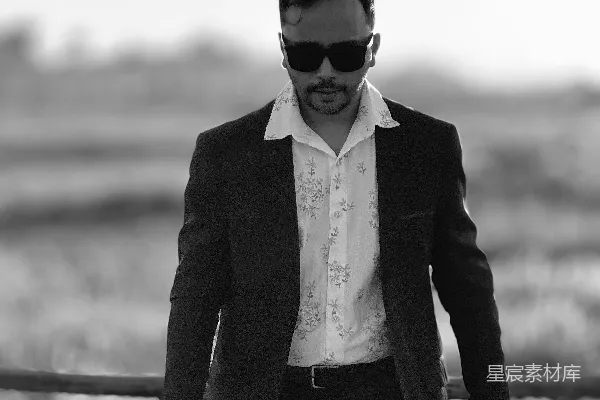 高清摄影 一个穿着西装带着墨镜的男人在桥上走过