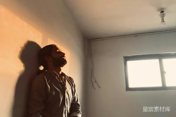 高清摄影 一个男人坐在一扇窗户旁边的墙上。