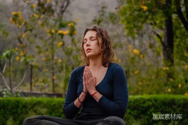 高清摄影 一位女性在公园里以瑜伽姿势坐着。