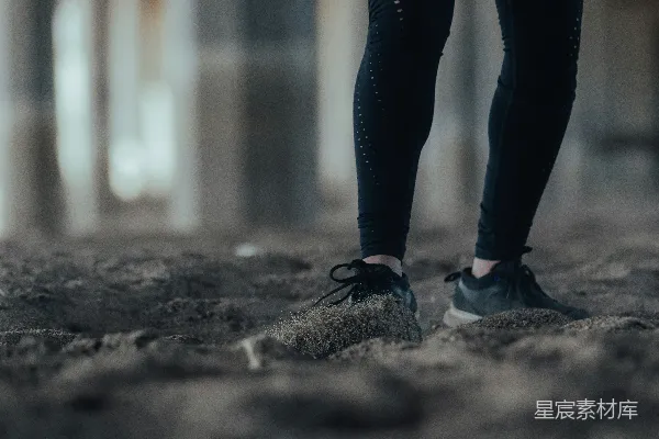 高清摄影 穿着黑色裤子和黑色鞋子的人站在灰色混凝土地板上。
