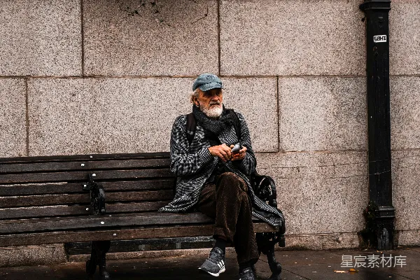 高清摄影 穿黑色夹克的男人坐在棕色木制长椅上