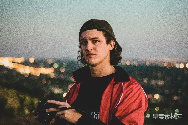 高清摄影 穿着红黑相间的拉链夹克的男人站在户外的白天。