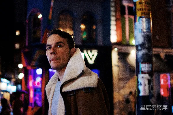 高清摄影 穿着棕色夹克的男人站在建筑物旁边。