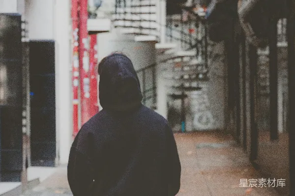 高清摄影 一个男人沿着人行道走过，旁边有一座高楼。