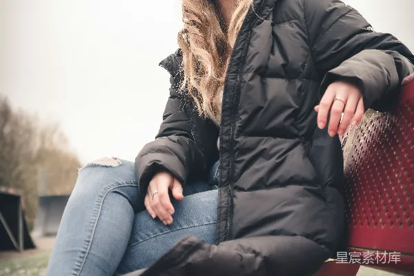 高清摄影 一个女人坐在红色的长椅上。