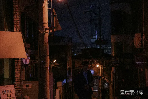 高清摄影 穿着黑色夹克和裤子的男人夜晚走在街上。