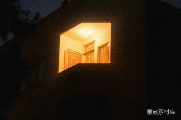 高清摄影 夜晚，一座昏暗建筑中一扇明亮的窗户。