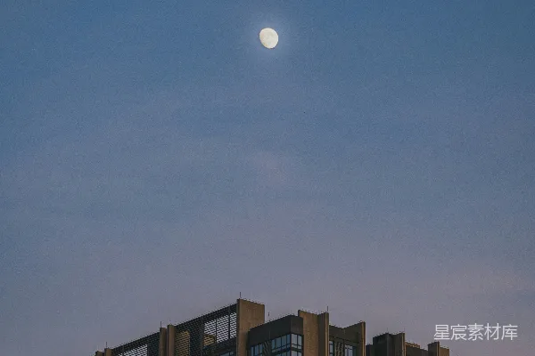 高清摄影 黄昏时分，一轮满月高挂在现代化高层建筑之上。